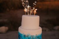07 a white wedding cake decorated with turquoise paint and white constellations, with gold stars and a black moon on top