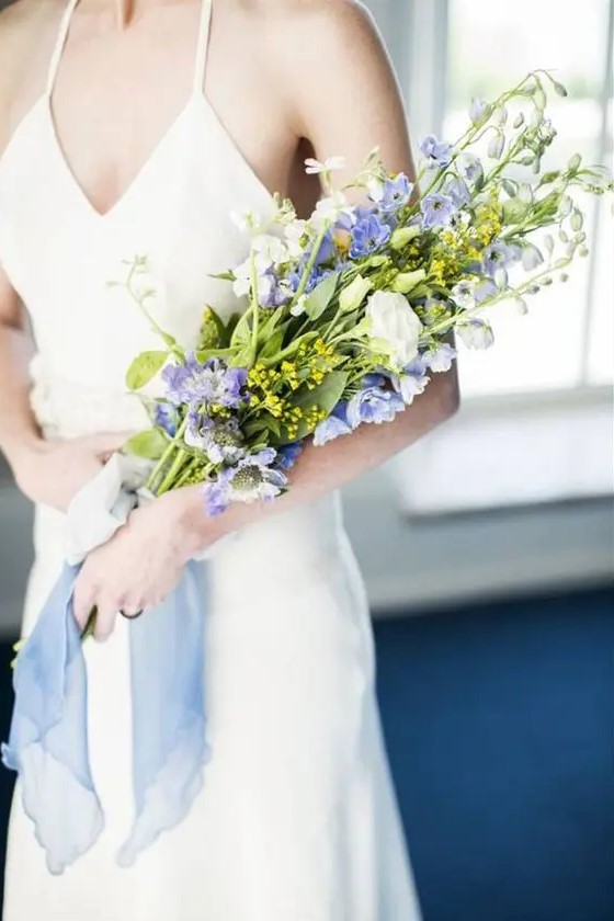 a cute and simple summer wedding bouquet of white roses and blue delphinium is a chic and cool idea for spring or summer