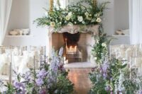 11 a sophisticated wedding ceremony space with a vintage fireplace and lush white blooms on the mantel, greenery, delphinium and purple flowers