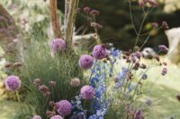 17 secret garden wedding decor with blue blooms, purple blooms and allium plus grasses is a bold and dimensional idea