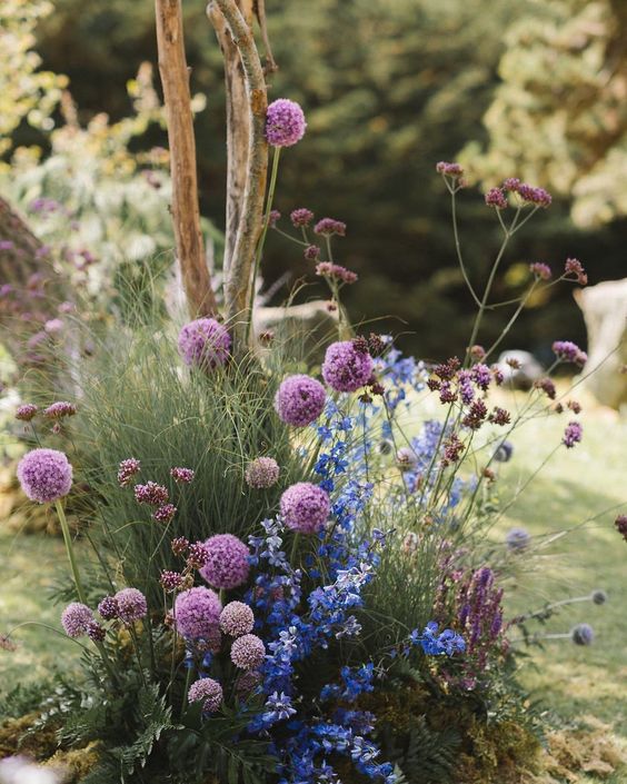 secret garden wedding decor with blue blooms, purple blooms and allium plus grasses is a bold and dimensional idea