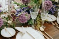 18 a beautiful and textural garden wedding centerpiece of allium, white ranunculus, purple irises and greenery is fantastic
