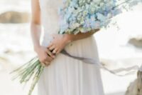 18 a romantic coastal bridal look with a strapless embellished wedding dress and a white and blue long stemmed wedding bouquet
