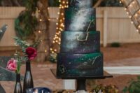 19 a black, grey and emerald space wedding cake with gold constellations and a whimsical cake topper for a celestial wedding
