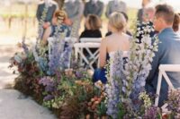 19 a bold and catchy wedding aisle decorated with purple delphinium, ornage, burgundy and yellow blooms and greenery