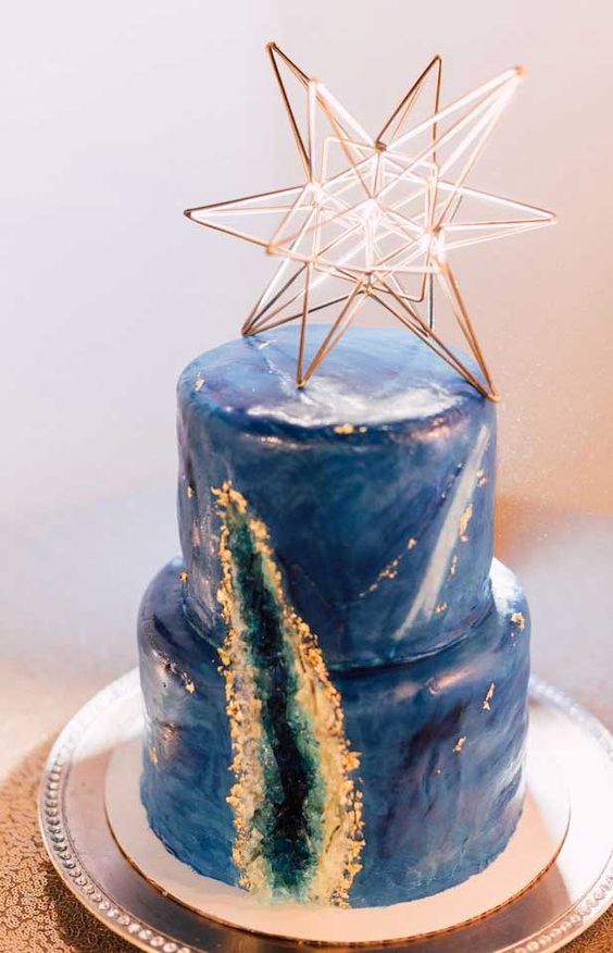 a blue starry night wedding cake with a geode detail, with gold leaf and a lovely lit up star cake topper is amazing
