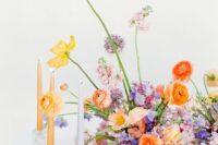 23 a bright and chic wedding centerpiece of orange, yellow, pink and blush blooms of various kinds, including allium and matching candles around