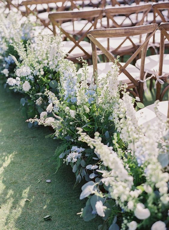 a dreamy wedding aisle accented with blue and white delphinium is a lovely and chic idea for a spring wedding
