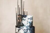 24 a dark navy and black watercolor wedding cake with constellations and thin black candles brings that wow factor