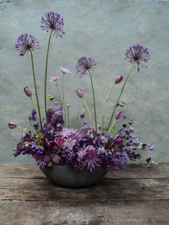 a moody wedding centerpiece in deep purple, mauve, violet, with allium and greenery is a lovely idea for the fall