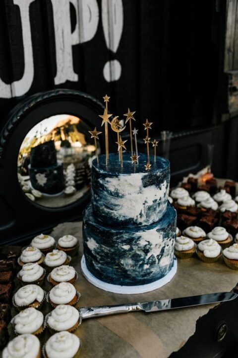 a lovely midnight blue and white wedding cake topped with gold stars and moons is a chic solution for a celestial wedding