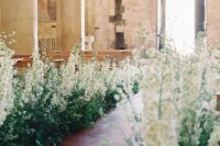 29 a wedding aisle turned into a wild garden one, with lots of greenery and white delphinium, is a gorgeous idea