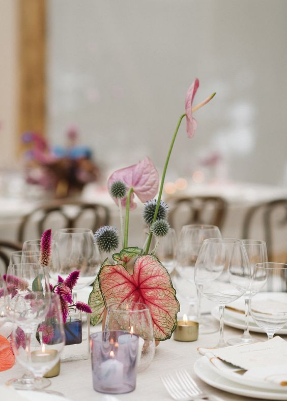 an ikebana-inspired wedding centerpiece with bold leaves, allium and some spray painted pieces is chic