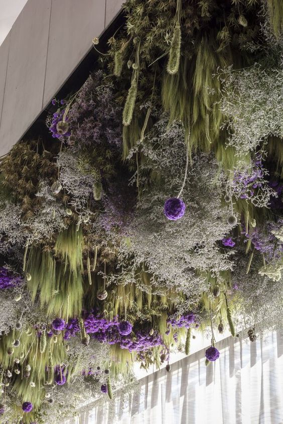 an overhead wedding installation with plenty of grasses and greenery, allium and purple tulips is a fantastic idea to rock