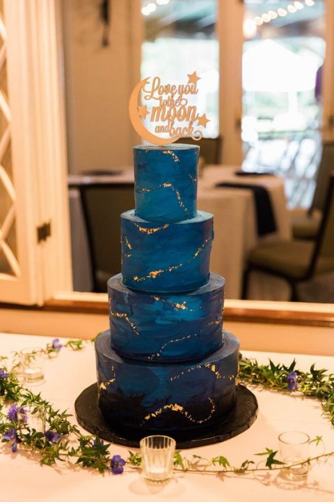 a starry night wedding cake with a gorgeous topper and a bit of gold leaf all over the cake is a gorgeous idea for a wedding