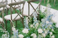 39 white roses, blue delphinium and greenery make the wedding ceremony space look beautiful, delicate and very spring-like