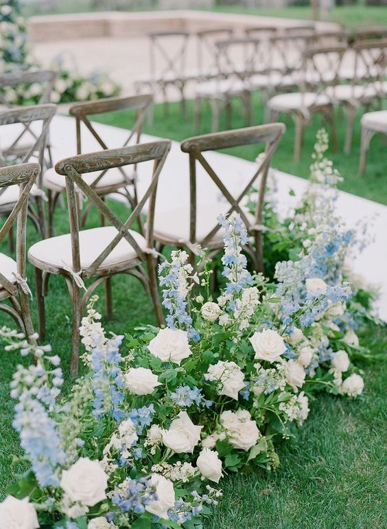white roses, blue delphinium and greenery make the wedding ceremony space look beautiful, delicate and very spring-like