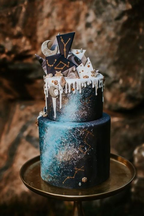 a watercolor navy wedding cake with gold constellations, white chocolate drip, dark and white chocolate shards with constellations and a moon