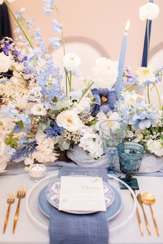 a fab wedding centerpiece composed of white, lilac and blue delphinium, white flowers and a bit of candles around