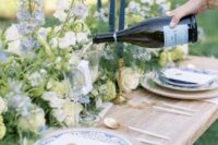 48 classic wedding table decor done with white and blue delphinium, greenery and blue printed plates is amazing