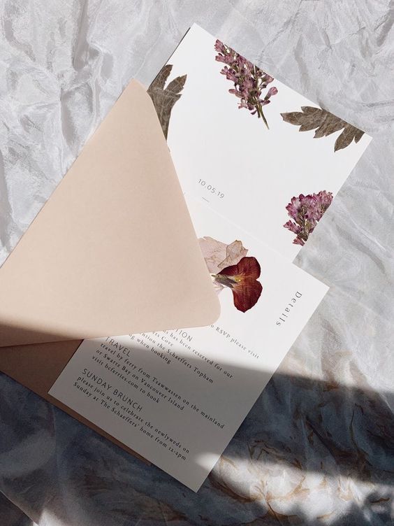 a beautiful pressed flower and leaf wedding invitation in a kraft paper envelope is a chic and stylish idea