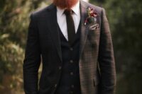 05 a brown plaid three-piece suite with a brown tie and a white shirt, a taupe handkerchief and a bold floral boutonniere