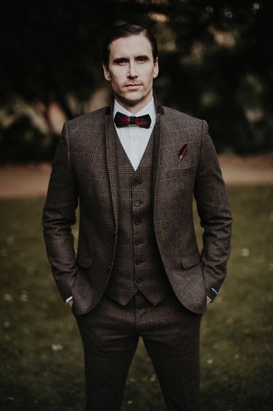 a brown plaid tweed three piece suit, a white button down, a burgundy bow tie for an elegant winter look