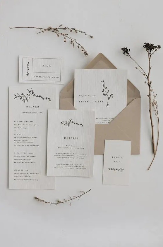 a minimalist wedding invitation suite in neutrals and with a kraft paper envelope, with black lettering and a bit of botanical prints