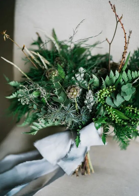 a lovely and textural wedding bouquet of greenery and evergreens, twigs and berries, seed pods and grey ribbon