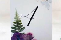 09 a super cool and bright pressed flower wedding table number with purple blooms and a leaf is amazing