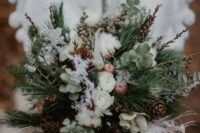10 a textural winter wedding bouquet of evergreens, greenery, twigs, berries, pinecones, cotton, feathers and lotus is amazing