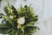 11 a modern wedding bouquet of fern, white ranunculus, small yellow bloom fillers is a catchy idea