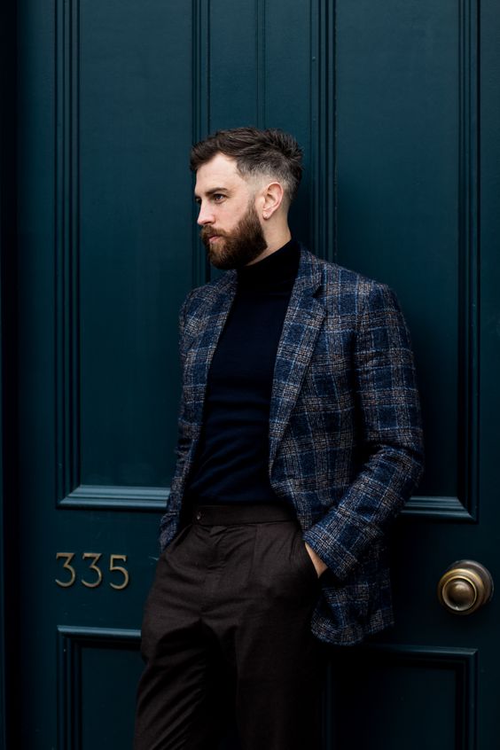 a modern to casual groom's look with a black turtleneck, brown pants, a grey and navy plaid blazer is a gorgeous idea