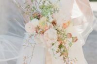 14 a unique S-shaped bouquet with delicately colored blooms, greenery and some twigs is a refined and chic solution for a wedding