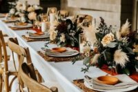 15 a beautiful fall backyard elopement table setting with woven placemats, neutral linens, pastel blooms, greenery and pampas grass plus candles