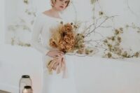 15 a minimalist winter bridal outfit with a white plain A-line wedding dress with a bateau neckline and long sleeves, a train and a headpiece with a veil