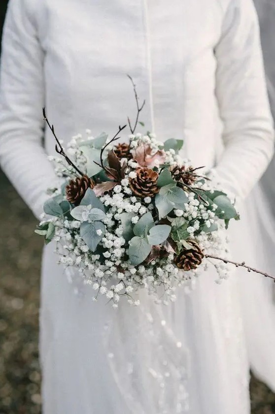 a winter wedding bouquet of greenery, baby's breath, pinecones and twigs plus some ribbon is amagical idea for winter
