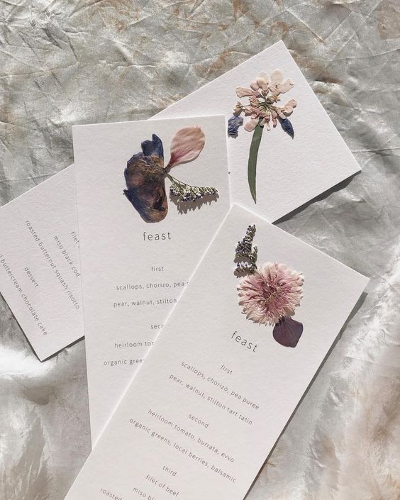 lovely pressed flower menus with very delicate printing are amazing for a spring or summer boho wedding