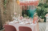 16 a little pink reception space right on the terrace of the house, with lush blooms, shiny fringe and candles
