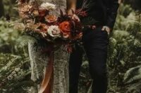 19 a luxurious moody woodland wedding bouquet of orange, burgundy, creamy and coffee blooms, branches with berries and long ribbons