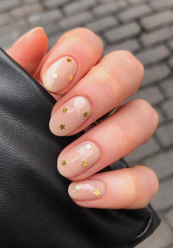 a nude wedding manicure with gold stars is a stylish and glam idea for a celestial bride