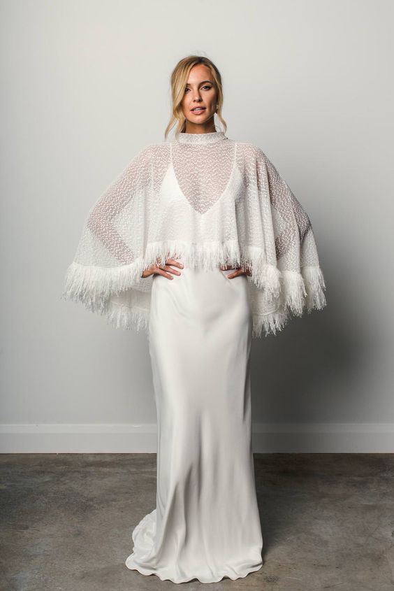 a beautiful sheer patterned capelet decorated with fringe is a bold and catchy solution for a fall or winter bride