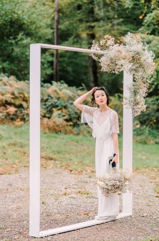 a minimalist wedding frame with some dried blooms and baby's breath is a bold and cool idea for a modern or minimalist wedding