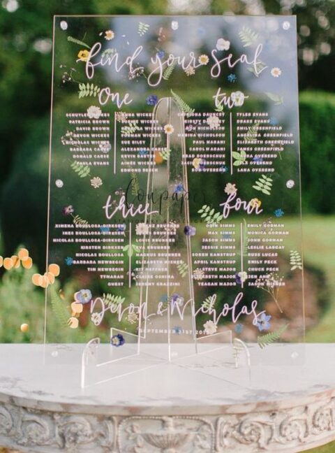 a beautiful wedding seating chart with some delicate pressed blooms and leaves and blush calligraphy is perfection for spring or summer
