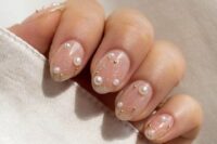 27 a stylish glam nude manicure with a touch of gold sparkle and pearls is a cool and lovely idea for a bride