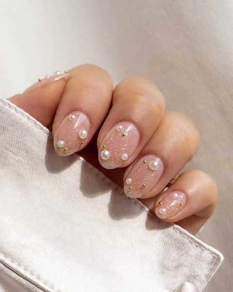 a stylish glam nude manicure with a touch of gold sparkle and pearls is a cool and lovely idea for a bride
