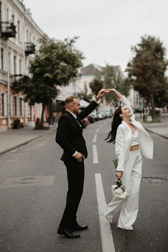 an oversized creamy pantsuit paired with a crop top are a great idea for a post elopement party in modern style