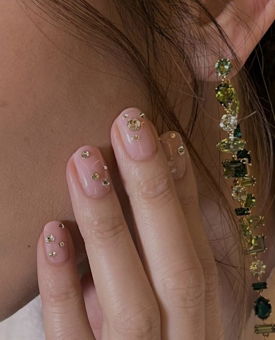 a super glam wedding manicure in blush, with large gold rhinestones is amazing for a glam bride