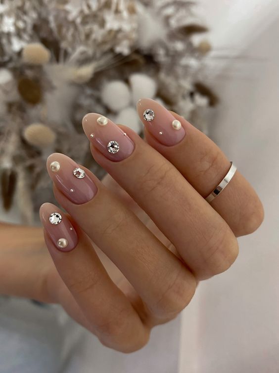 a super glam wedding manicure with pearls and rhinestones is a catchy idea with a bold romantic statement