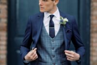 31 a navy pantsuit, a grey plaid waistcoat, a white shirt, a navy tie and a white boutonniere are a timelessly stylish and chic look for a groom